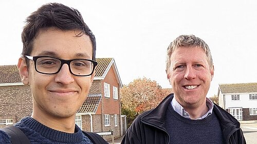 Head and shoulders of Freddie Hoareau and James MacCleary with a suburban background of houses and trees.