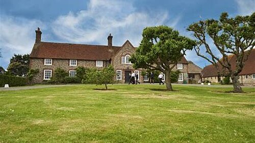 old style school buildings seen across an expanse of grass and trees