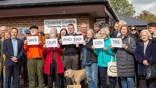 James MacCleary, town councillor Kevin West and others, including a dog, outside the Phoenix Centre, holding cards that say "Save our Phoenix Centre"