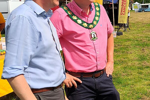 At the Polegate Fun Day, James and a man with a medallion, possibly the mayor, watch something happening off screen to the right.