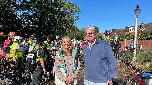 Councillors Sarah Osborne and Paul Mellor with a large group of cyclists. The cyclist are all in safety gear and two of them have "Marshal" signs on their kit.