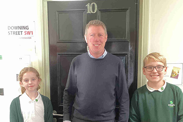 James with two Polegate Primary pupils in front of a mock up of the door of number 10 Downing Street. perhaps where James wants to be in a few years time.