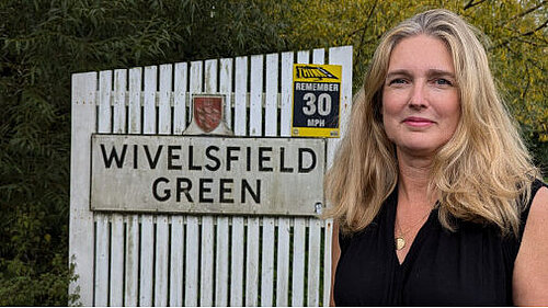 Nadine Stothard at the village sign for Wivelsfield Green