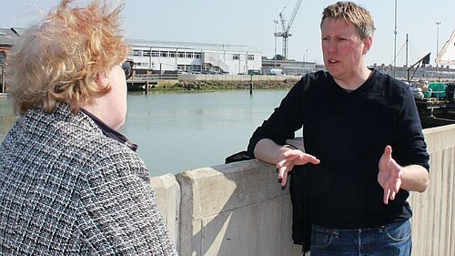 James MacCleary explaining a point with the river and cranes in the background.