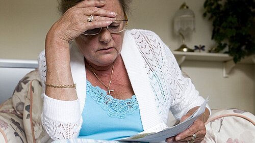 A lady looking at her bills.