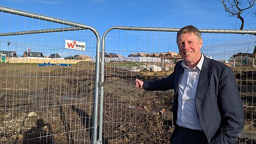 James standing by safety barriers at a building site. He looks excited - fr once he has reason as this is potentially where Willingdon's new health facility will be sited.