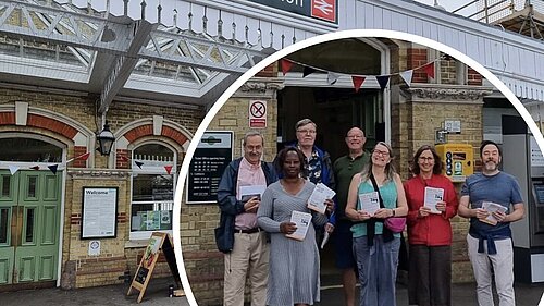 Facade of Lewes railway station with inset picture of several LibDems holding petition forms