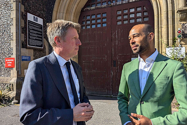 James with Josh Babarinde in front of the imposing wooden gates of Lewes prison