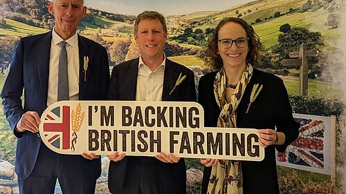 James MacCleary with fellow LibDem MPs Alison Bennett and John Milne holding a sign that says "I'm backing British farming"