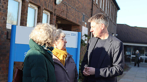 James talking to residents outside an NHS facility