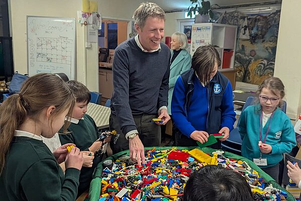 James with several school children of various ages and an immense bucket of Lego. James looks very hpapy.